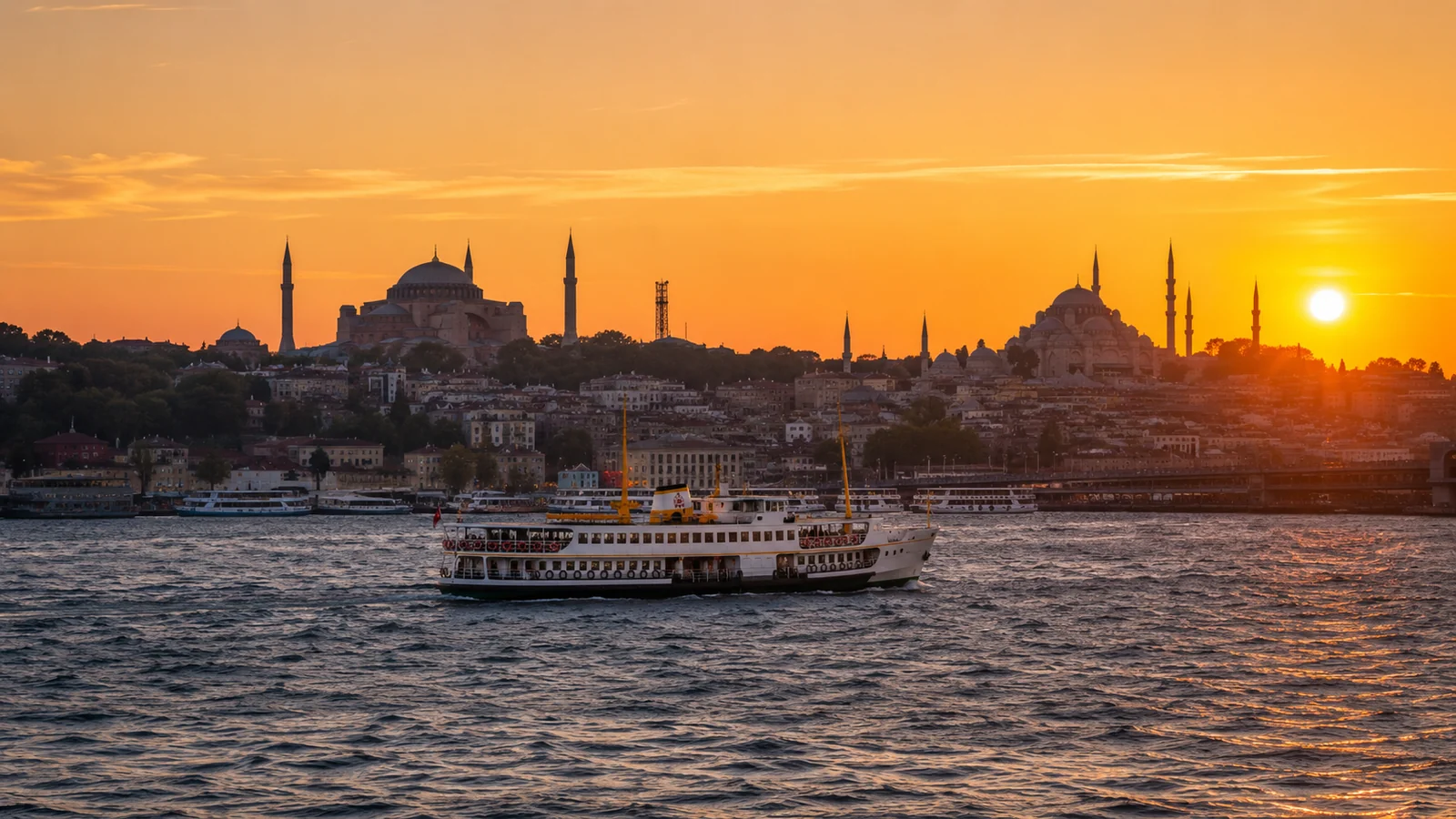 Panorama Istanbulului la apus, cu moscheile din Sultanahmet și un feribot pe Bosfor